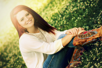 A red haired girls in a field of flowers