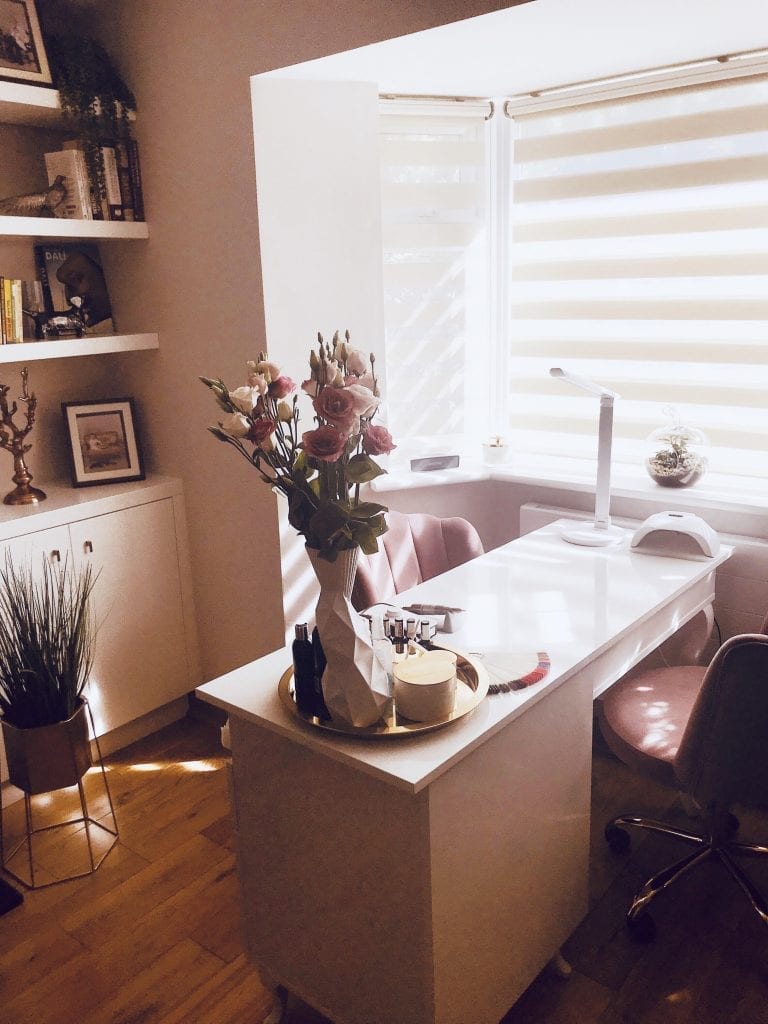 pink salon with table and chairs with pink flowers in a vase 